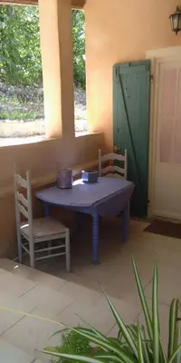 a table in a room with two chairs and a door at Bienvenue à la Source dans une Maison de Charme in Apt