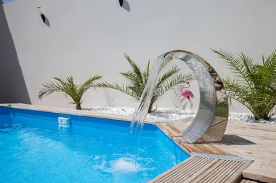 a flamingo water fountain in a swimming pool at Les Villas des Fontaines in Saumane-de-Vaucluse