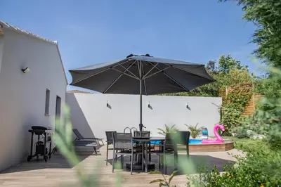 a patio with an umbrella and a table and chairs at Les Villas des Fontaines in Saumane-de-Vaucluse