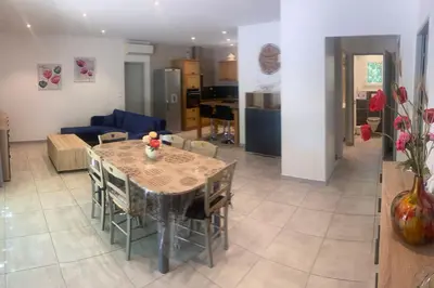 a dining room and living room with a table and chairs at Le Ribbou in LʼIsle-sur-la-Sorgue