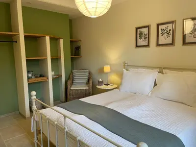 a bedroom with a large bed and a chair at Le Mas de Caroline in Gargas