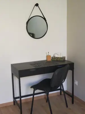 a black desk with a chair and a mirror at Gîte Les Demoiselles des Sorgues in LʼIsle-sur-la-Sorgue