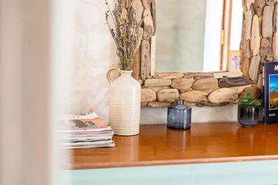 a white vase sitting on a wooden shelf with magazines at Au petit bonheur in Bédoin