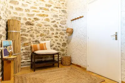 a chair in a room with a stone wall at Au petit bonheur in Bédoin
