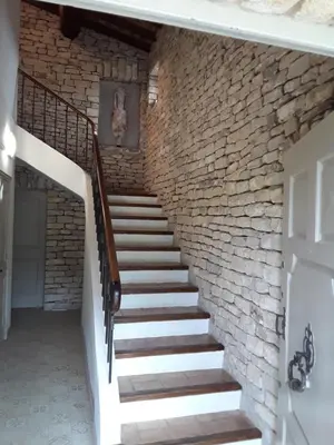 a brick staircase in a house with a stone wall at Chambre du sentier des ocres in Roussillon