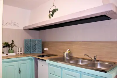 a kitchen with blue cabinets and a sink at Calme et Intimité proche Avignon Piscine options au choix privée ou partagée de juin à octobre in Morières-lès-Avignon