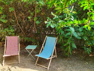two chairs and a table in front of a fence at Calme et Intimité proche Avignon Piscine options au choix privée ou partagée de juin à octobre in Morières-lès-Avignon