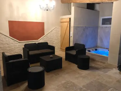 a waiting room with chairs and a hot tub at Au milieu des Piboules de Provence. in LʼIsle-sur-la-Sorgue