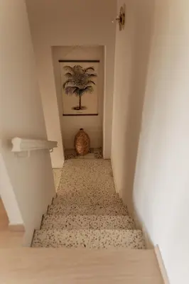 a hallway with a staircase with a palm tree on the wall at GITE LE TILLEUL in Mormoiron