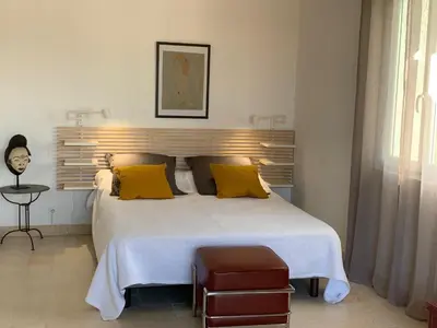 a bedroom with a large white bed with yellow pillows at Les Moineaux in Rustrel
