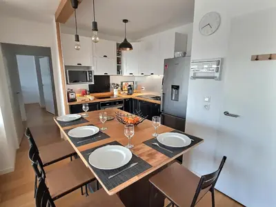 a kitchen with a table and chairs with plates and glasses at Vaste appartement avec terrasse, parking, proche Parc Expo Avignon in Avignon