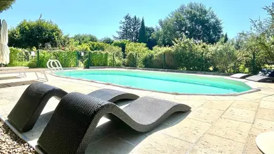 a swimming pool with two lawn chairs and a swimming pool at Rendez-vous avec les cigales - gîte 6 personnes 100m2 - piscine privée - Climatisation in Cheval-Blanc