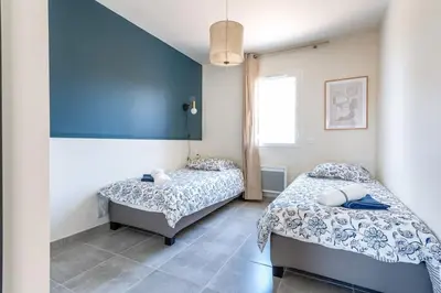 a bedroom with two beds and a blue wall at ☆ Blue Provençal Appartement ☆ in Morières-lès-Avignon