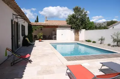 a swimming pool in the backyard of a house at charming vacation rental with heated pool at the foot of the alpilles, in aureille, close to the center of the village on foot, sleeps 6/8 people in provence. in Aureille