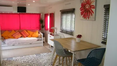 a living room with a bed and a table and chairs at Chalet de Provence in Aix-en-Provence