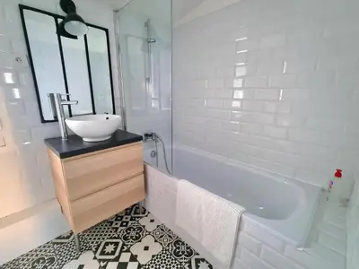 a white bathroom with a sink and a tub at Un balcon sur les toits d'Aix in Aix-en-Provence