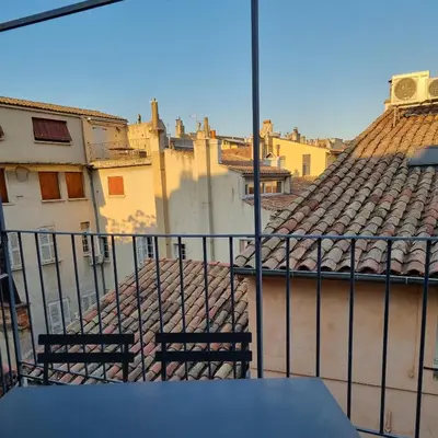 a view of a balcony with two chairs and buildings at Un balcon sur les toits d'Aix in Aix-en-Provence
