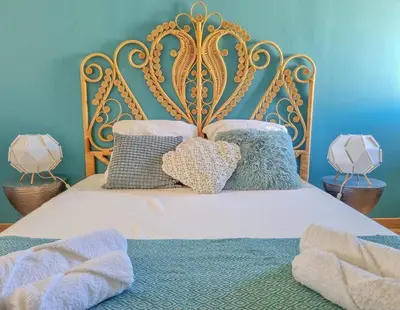 a bed with a gold frame and pillows on it at Un balcon sur les toits d'Aix in Aix-en-Provence
