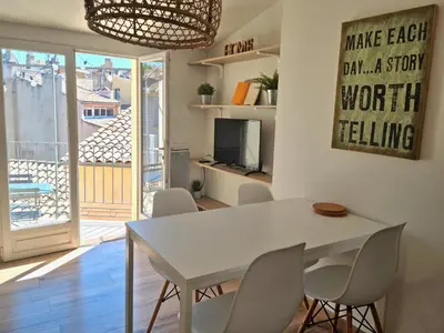 a dining room with a white table and chairs at Un balcon sur les toits d'Aix in Aix-en-Provence