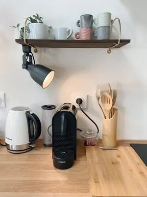 a kitchen counter with a coffee maker and cups on a shelf at Bonnieux : Loft - La pause in Bonnieux