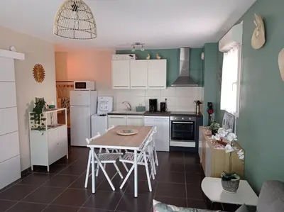 a kitchen with white appliances and a table at LE SOLEIL DU LUBERON - T2 avec Terrasse, Parking et Clim in LʼIsle-sur-la-Sorgue