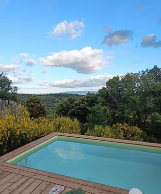 a swimming pool on top of a wooden deck at chambre d'hôtes Et Puis Voilà! in Murs