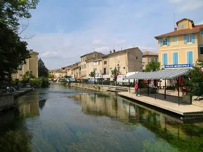 a river in a city with buildings next to a street at Appartement à L'Isle-sur-la-Sorgue avec vue sur la ville in LʼIsle-sur-la-Sorgue