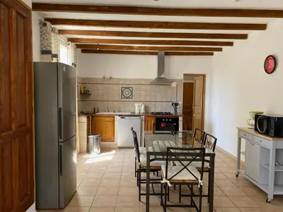 a kitchen with a table and chairs and a refrigerator at Les Célestins - Villa en Provence in Carpentras