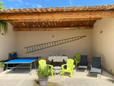 a patio with a ping pong table and chairs at Les Célestins - Villa en Provence in Carpentras