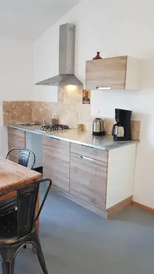 a kitchen with a counter and a table with chairs at le moulin in Crillon-le-Brave