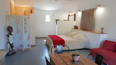 a bedroom with a bed and a table and a chair at le moulin in Crillon-le-Brave