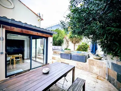 a patio with a wooden bench and a table at Maison avec piscine, jacuzzi et sauna privatifs - Mas de Nebbas in Aix-en-Provence