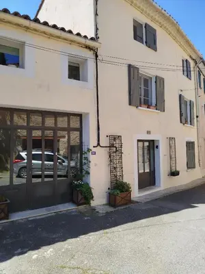a pink ribbon is attached to the side of a building at A l'Ombre de la Dame in Cucuron