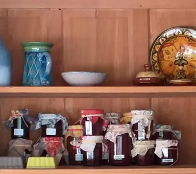 a shelf with food items and a clock on it at Les Chêneslierres in Lourmarin