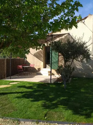 a garden with a table and chairs in a yard at Les Chêneslierres in Lourmarin