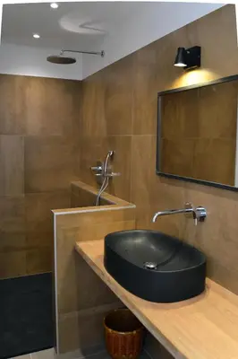 a bathroom with a black sink and a mirror at Les Chêneslierres in Lourmarin