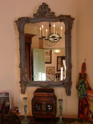 a large mirror on a wall with a dresser in a room at Lou Amourie in Roussillon