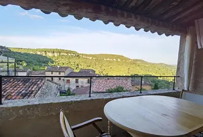 a table and chairs on a balcony with a view at Romantic Provencal house with terrace in Saignon