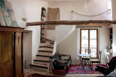a living room with a staircase and a table at Romantic Provencal house with terrace in Saignon