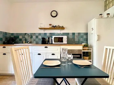 a kitchen with a black table and a white refrigerator at Lou Maestoso - Cosy, Campagne, CLIM, 2 personnes in Lançon-Provence