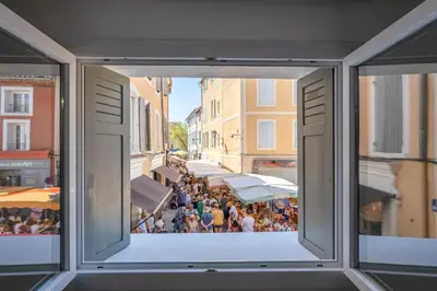 a view from a window of a crowd of people at L'IRIS D OR - 3 Étoiles- 3ème étage in LʼIsle-sur-la-Sorgue
