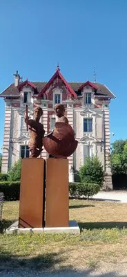 a statue of two people in front of a house at L'IRIS D OR - 3 Étoiles- 3ème étage in LʼIsle-sur-la-Sorgue
