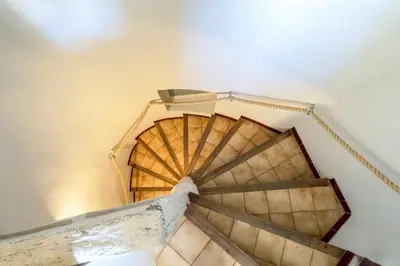 an overhead view of a wooden spiral staircase at L'IRIS D OR - 3 Étoiles- 3ème étage in LʼIsle-sur-la-Sorgue