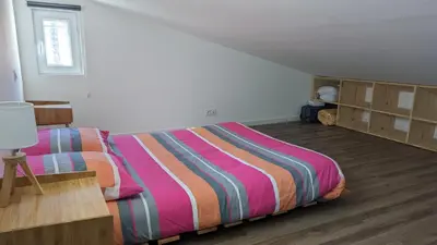 a bedroom with a bed with a colorful striped comforter at Adorable petite maison au coeur du Luberon in Villelaure
