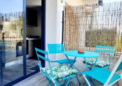 a blue table and chairs on a patio at Adorable petite maison au coeur du Luberon in Villelaure
