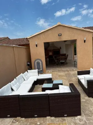 a patio with white couches and a table at Magnifique maisonnette Dépendance avec Piscine in Châteaurenard