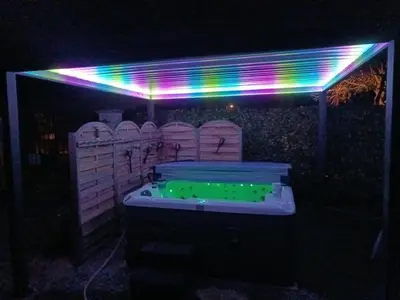 a lit up hot tub in a backyard at night at La Remise de Guytou et Spa in Cheval-Blanc