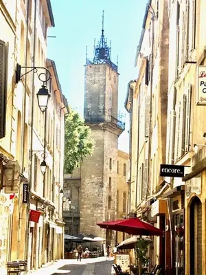 a city street with a clock tower in the background at Petit cocoon Aixois in Aix-en-Provence