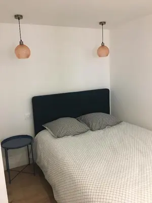 a bedroom with a bed with two lights above it at Petit cocoon Aixois in Aix-en-Provence