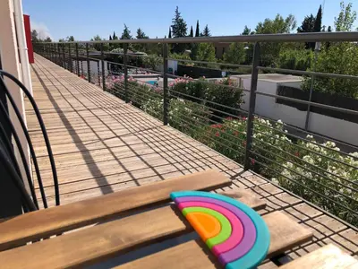 a wooden bench sitting on top of a balcony at Ma place au sud 1 in Éguilles